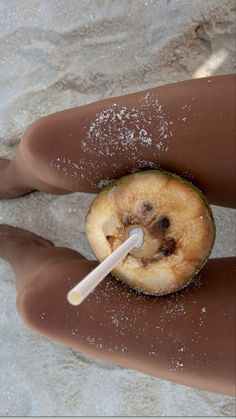 a person's legs covered in white powder and an apple with a straw sticking out of it