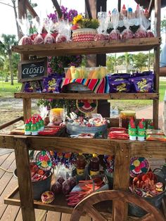 a wooden cart filled with lots of food on top of a wooden floor next to trees