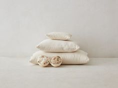 three pillows stacked on top of each other with two slippers laying next to them