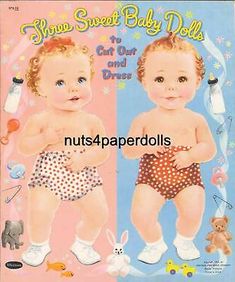 two baby dolls are wearing diapers and standing next to each other