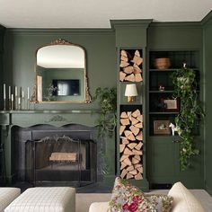 a living room filled with furniture and a fire place in front of a green wall