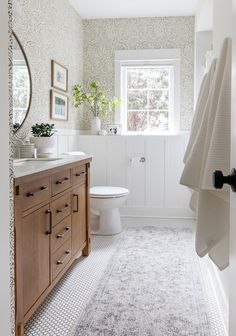 a bathroom with a rug, sink and toilet in it's centerpieces