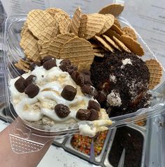 an ice cream sundae with chocolate chips and cookies on top in a plastic container