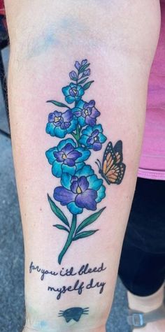 a woman's arm with a blue flower and butterfly tattoo on the left side