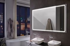 a bathroom with two sinks and a large mirror on the wall next to bathtub