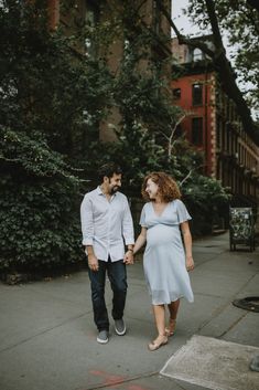 a man and woman walking down the street holding hands