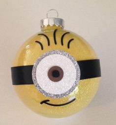 a yellow glass ornament with a black and white stripe around the eyeball