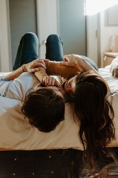 two people laying on top of a bed next to each other