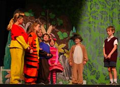 children in costumes standing on stage with adults