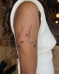 a woman's arm with flowers on it and the word love written in cursive writing