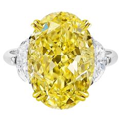 This exquisite ring features a captivating 5.04 carat fancy yellow oval diamond as its centerpiece, certified by GIA. The vibrant yellow diamond is set in 18K white gold, creating a stunning contrast that enhances it's rich color. Flanking the central stone are two elegant half moon diamonds, adding balance and brilliance to the overall design. The double prongs, crafted in 18K yellow gold, securely hold the diamond while subtly accentuating it's radiant hue. With a VS1 clarity grade, the diamon Oval Diamond Solitaire Ring, Fancy Yellow Diamond Ring, Oval Diamond Solitaire, Trillion Diamonds, Yellow Diamond Ring, Contemporary Engagement Rings, Oval Diamond Ring, Yellow Diamond Rings, 26 November