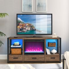 a flat screen tv sitting on top of a wooden entertainment center in a living room