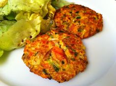 two crab cakes on a plate next to a salad