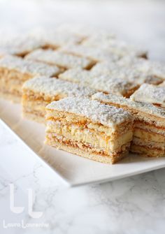 several pieces of cake on a plate with powdered sugar toppings, ready to be eaten