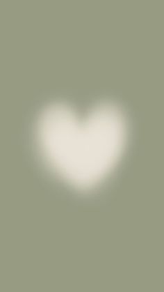 a white heart shaped object in the middle of a gray background with light coming from it