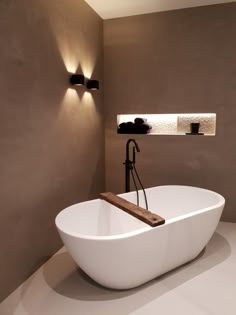 a white bath tub sitting in a bathroom next to a wall mounted shelf with lights on it