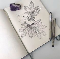 a drawing of a bird sitting on top of a leaf covered book next to two crayons