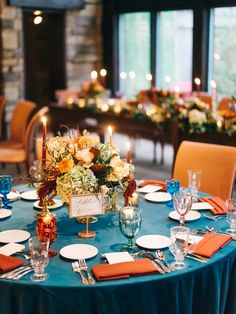 a table set up with place settings and flowers