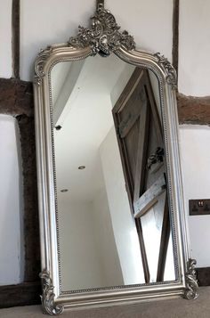 a large silver mirror hanging on the wall