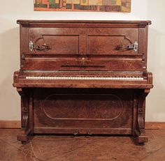 an old piano sitting in front of a painting