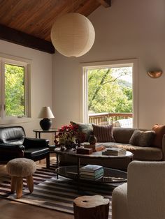 a living room filled with furniture and large windows