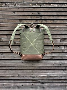 "Backpack made from heavy weight waxed filter twill in the color olive green with an outside pocket made in oiled leather.(color of the leather is dark taupe) I made it into an everyday backpack/rucksack, with waxed filter twill padded straps. Roll to close top, and outside pocket with protective flap, bottom and roll to close piece made in oiled leather. The bag closes with roll to close system and double snap closing This rucksack is fully lined with a cotton canvas fabric, and a padded backsi Khaki Waxed Canvas Backpack For Outdoor, Khaki Waxed Canvas Backpack, Khaki Waxed Canvas Standard Backpack, Everyday Waxed Canvas Backpack With Leather Patch, Waxed Canvas Backpack, Canvas Leather Bag, Everyday Backpack, Cotton Canvas Fabric, Canvas Bags