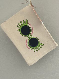 a bag hanging on the wall with an eyeball and two hands drawn on it