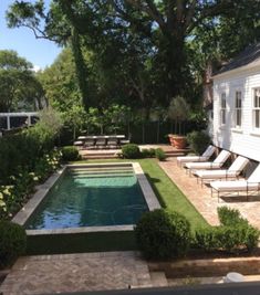 an outdoor pool surrounded by lawn chairs and trees