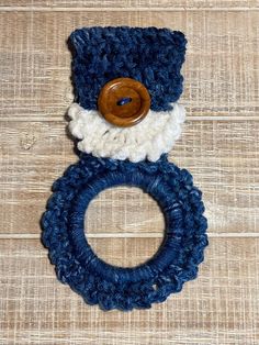 a crocheted blue and white ring with a wooden button