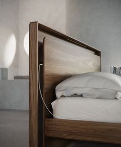 a wooden bed with white sheets and pillows