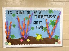 a bulletin board with turtles and seaweed on it's side in front of a wall