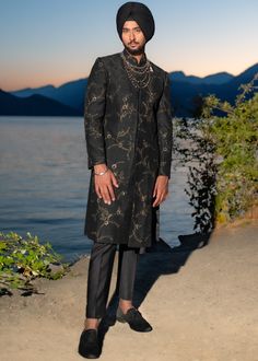 Presenting the iris achkan from our new collection monet, with hints of gold over a black ensemble, perfect all your upcoming night functions! Paired with tapered trousers. Gold Festive Evening Suit, Elegant Sherwani For Festive Evening, Elegant Evening Sherwani For Festive Occasions, Elegant Black Evening Kurta, Black Sherwani With Zari Work For Semi-formal Occasions, Luxury Black Kurta For Festive Occasions, Fitted Gold Sherwani For Semi-formal Events, Gold Fitted Sherwani For Semi-formal Events, Black Semi-formal Set With Zari Work