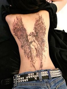 the back of a woman's stomach with an angel tattoo on her lower back