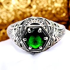 Discover the timeless elegance of our vintage 925 solid sterling silver simulated emerald filigree ring. This exquisite piece features a vibrant green, round-cut simulated emerald stone that captures the light beautifully, adding a touch of brilliance to any ensemble. Crafted with meticulous attention to detail, the intricate filigree design showcases the artistry and craftsmanship that defines our collection. The ring is stamped with the 925 hallmark, ensuring its authenticity and quality as a sterling silver treasure. Measuring a perfect balance of sophistication and charm, this ring is versatile enough for both everyday wear and special occasions. Whether you're treating yourself or searching for a memorable gift, this ring is sure to impress.  Treat yourself or a loved one to this time Luxury Sterling Silver Classic Filigree Ring, Luxury Classic Filigree Ring For Collectors, Luxury Engraved Silver Emerald Ring, Luxury Silver Engraved Emerald Ring, Luxury Art Deco Sterling Silver Filigree Ring, Exquisite Silver Emerald Ring, Luxury Handmade Sterling Silver Emerald Ring, Luxury Classic Sterling Silver Emerald Ring, Luxury Vintage Emerald Ring In Sterling Silver