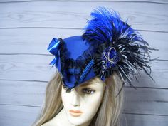 "Beautiful royal blue woolen felt ladies tricorn hat with black ruffled trim, royal blue braid, royal blue and black ostrich feathers, black and white ostrich fringe, two royal blue satin bows and black cocarde with a jewel center. The inside circumference is 22.5\" with a built-in adjustable string. Just cinch and tie for a better fit. Perfect for Renaissance Fairs, Gasparilla Pirate event, 1800's Victorina events or even Halloween. I have many other hats in my shop if you would like to view them. I ship Priority mail. I ship many times a week. If you need your item quicker let me know your zip code and I can figure shipping rates for you. Please let me know if you have any questions   All sales are FINAL, no returns or exchanges please keep this in mind before purchasing. International b Blue Costume Hat For Carnival, 1800s Style, Tricorn Hat, Pirate Hat, Steampunk Hat, Pirate Hats, Doll Hat, Fancy Hats, Costume Hats