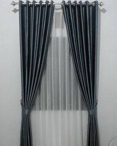 the curtains are hanging on the wall in the living room with white walls and black drapes