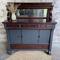 an antique dresser with mirror and vase on top