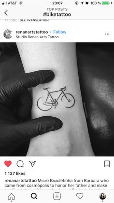 a person with a tattoo on their arm holding a bike in one hand and the other hand behind them