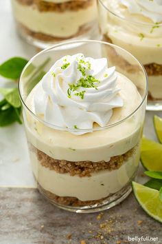 three desserts with lime and whipped cream in small glass dishes on a marble surface