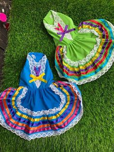 three colorful dresses laying on the grass