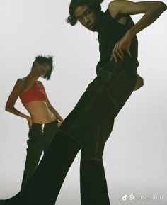 two women in black and red clothing are posing for the camera with their hands on their hips