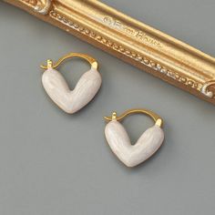 Description:Geometric Enamel Heart Earrings Specifications:Material: Copper, 18k Gold, EnamelColors: Pink/Blue/WhiteSize: 1.8 cm * 1.6 cmWeight: 6 g/pair Spice up your accessories game with these heart-shaped earrings! Made with precision and coated with vibrant enamel, these earrings are a perfect blend of classic and modern styles. A geometric twist on a traditional design, these earrings are a quirky and charming addition to any outfit. Gold Enamel Heart Earrings, Gold Heart-shaped Enamel Earrings, Gold Enamel Heart-shaped Earrings, White Heart Charm Earrings, White Enamel Hoop Earrings For Gifts, Minimalist White Heart Earrings For Everyday, Trendy White Heart-shaped Earrings, Trendy White Heart Earrings Gift, Trendy White Heart Earrings For Gift