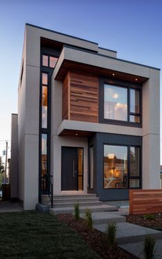 a modern house with wood and glass on the front door, stairs leading up to the second floor