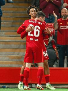 two soccer players are hugging each other on the field