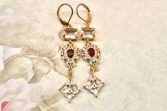 Red and Gold Earrings- Art Deco Earrings- Flapper Earrings- Great Gatsby- Old Hollywood- Vintage Inspired 1920's Earrings- Downtown Abbey Hanging from a rectangular clear glass connector  Are red and clear cubic zirconia drops with a fan  shaped CZ drop They are 2 1/2 inches long and suspend from gold plated lever back ear wires.  They arrive in a gift box with a bow Thanks for looking, Lori Vintage Red Dangle Chandelier Earrings, Red Vintage Dangle Chandelier Earrings, Red Vintage Chandelier Dangle Earrings, Elegant Red Plug Earrings For Party, Red Pierced Earrings For Wedding, Red Pierced Wedding Earrings, Red Dangle Chandelier Earrings For Anniversary, Classic Red Earrings For Party, Classic Red Party Earrings