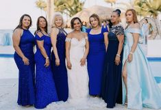 a group of women standing next to each other in front of a blue swimming pool