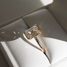 an engagement ring with a baguette cut diamond in it on a white box