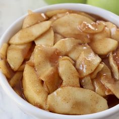 apples are in a white bowl with caramel sauce