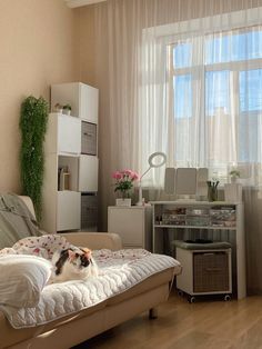 a cat laying on top of a bed in a room