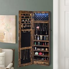 an open wooden cabinet with jewelry hanging from it's sides, in a living room